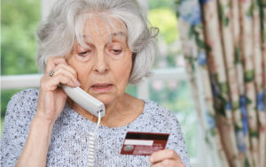 Elderly women on phone with credit card